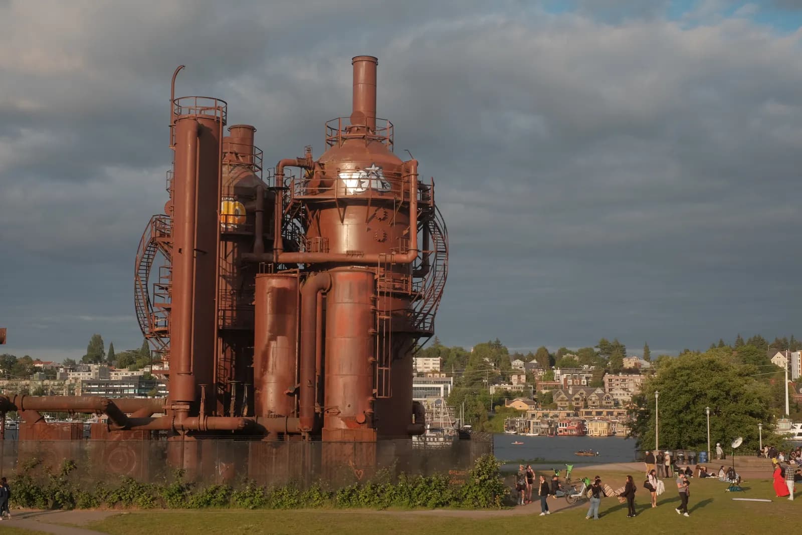 Rusted industrial gas works machinery at Gas Works Park, Seattle, against a cloudy sky with the city skyline in the background.