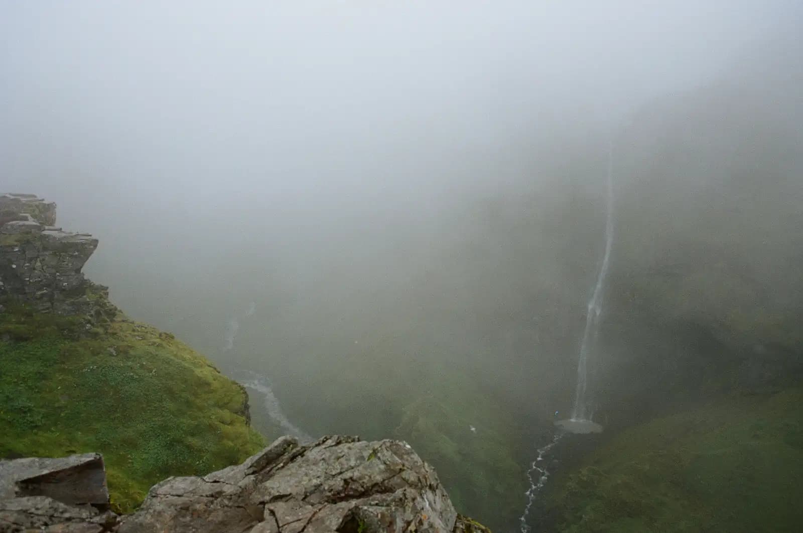 Waterfall emerging from fog, representing the layers of signal beneath AI citation decisions where structural formatting is one visible surface above deeper factors like semantic relevance and brand authority