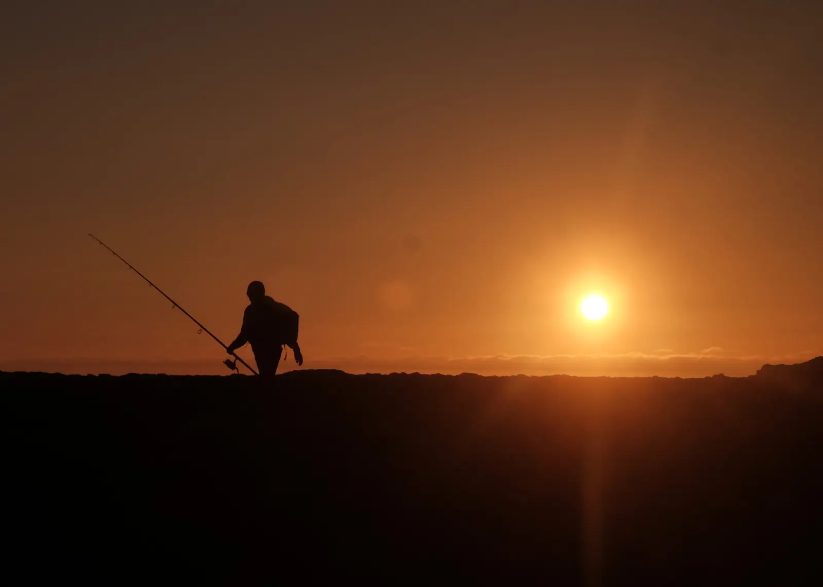 Silhouette of a fisherman at sunset, returning to the same spot each day, evoking the persistence question: will the brand appear again tomorrow?
