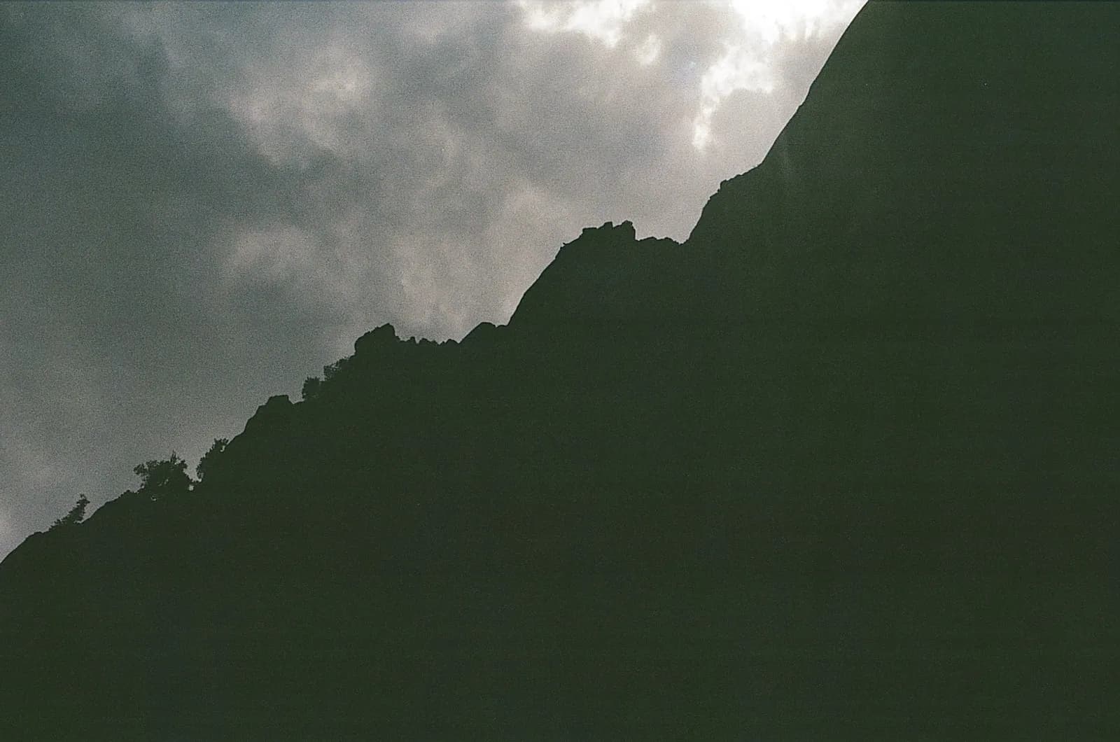 Mountain ridge silhouette rising against a stormy sky, representing the gap between strategic ambition and the measurement foundation needed to reach it