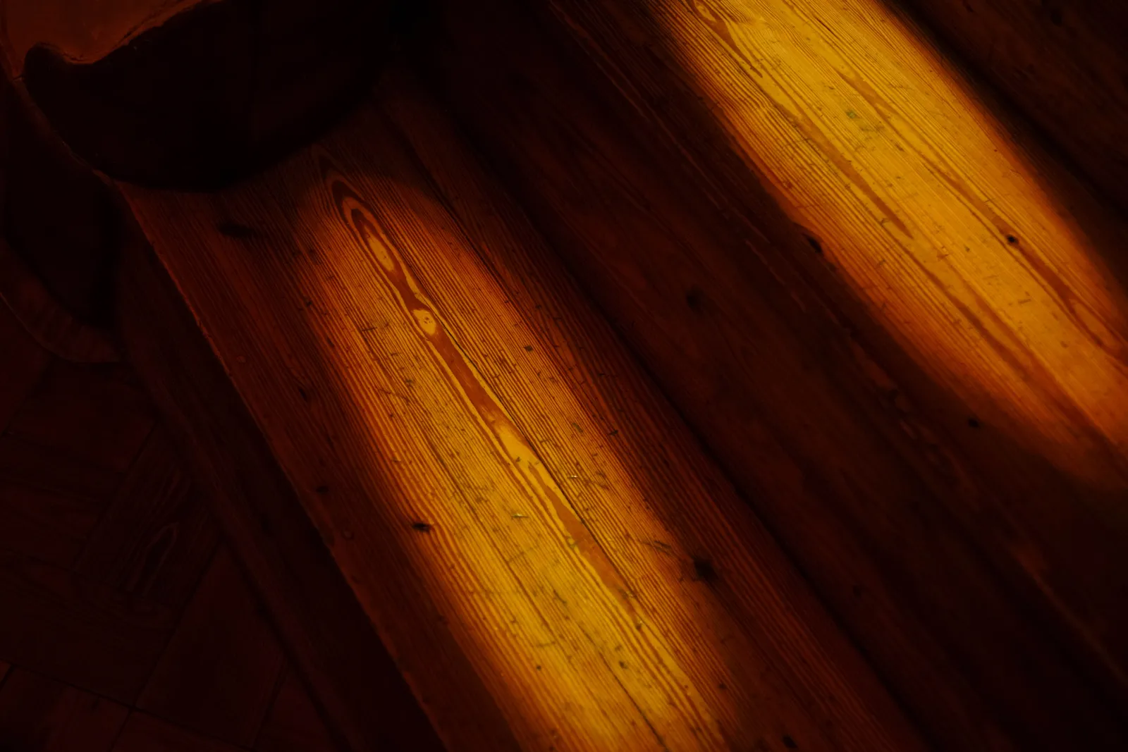 Warm light falling across wood grain, evoking the idea of the same surface seen differently depending on the angle of light.