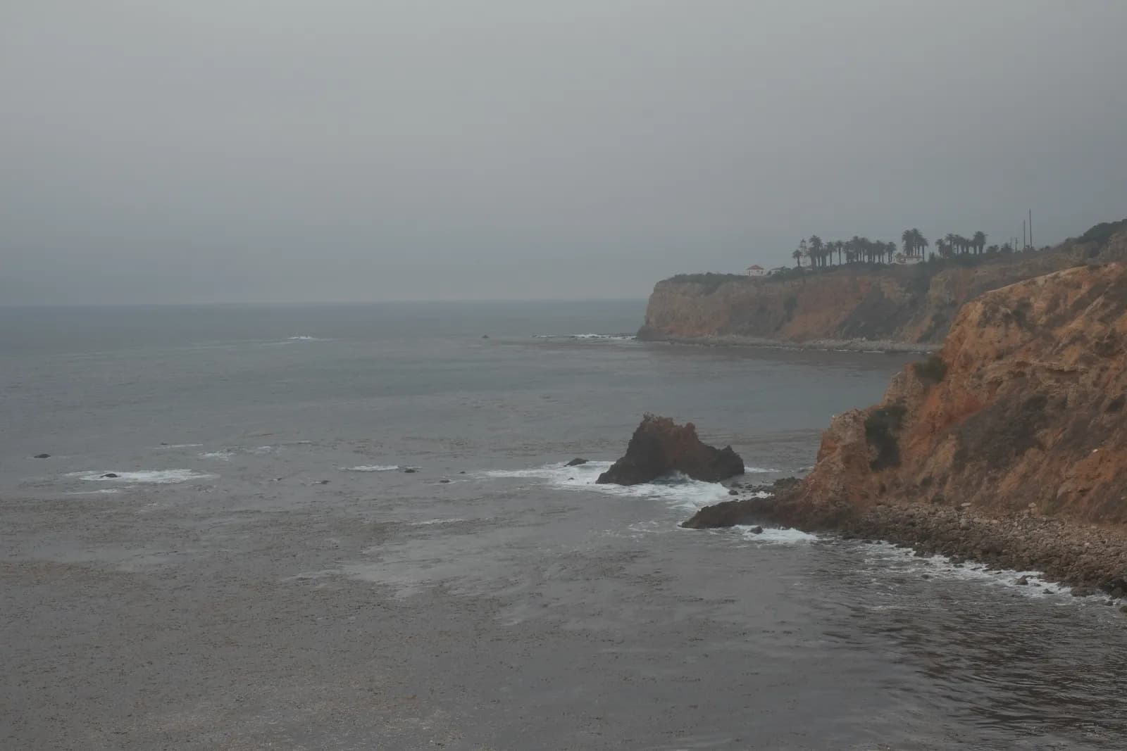 A coastline partially obscured by fog, with one shoreline visible and the rest hidden — visual metaphor for how a brand can be visible on one AI platform and absent from others.